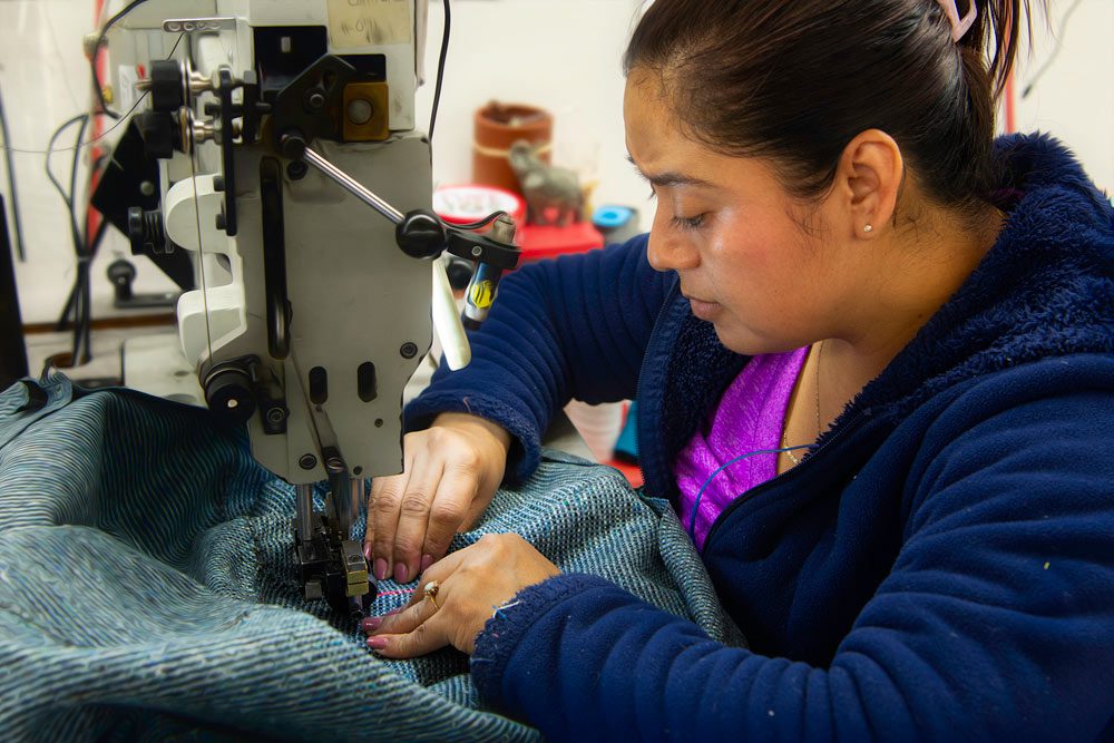 Female worker sewing the cover for a furniture